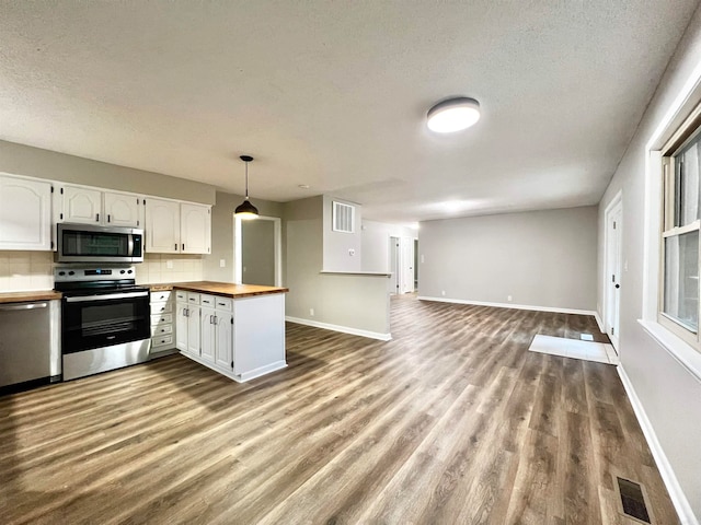 kitchen featuring white cabinets, pendant lighting, stainless steel appliances, and kitchen peninsula