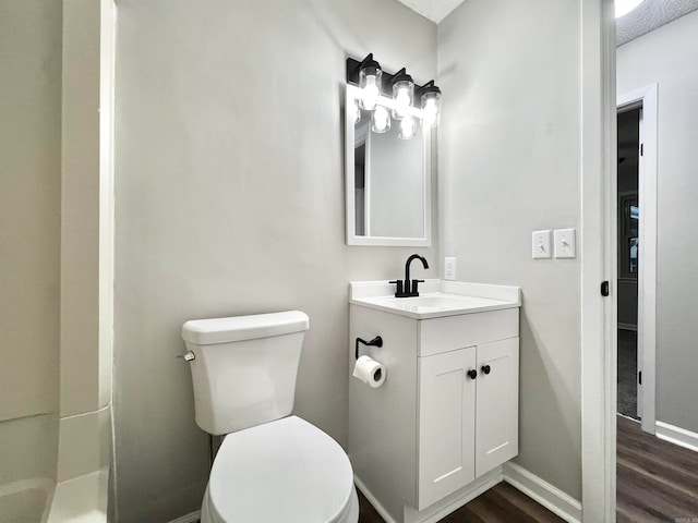 bathroom featuring a textured ceiling, vanity, wood-type flooring, toilet, and a shower