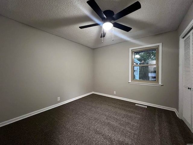 empty room with a textured ceiling, ceiling fan, and carpet floors