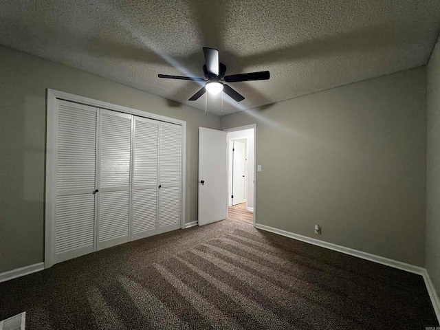 unfurnished bedroom featuring a textured ceiling, ceiling fan, and carpet