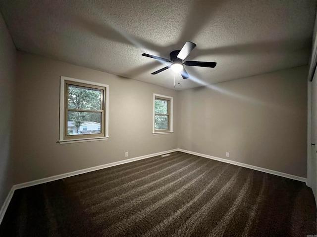 carpeted empty room with ceiling fan and a textured ceiling