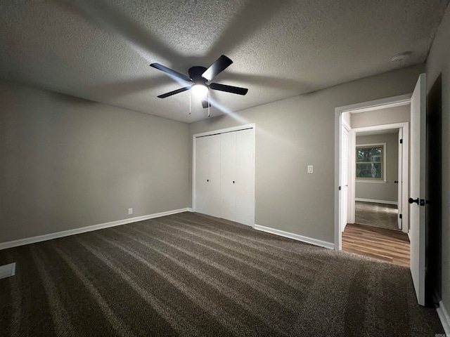 unfurnished bedroom featuring a textured ceiling, ceiling fan, a closet, and carpet floors