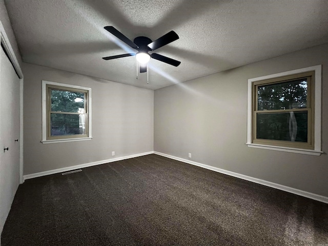 spare room with ceiling fan, carpet floors, and a textured ceiling