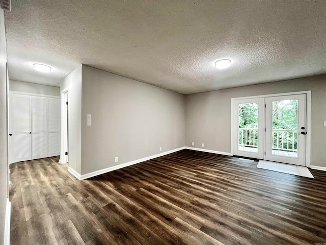 spare room featuring dark hardwood / wood-style floors and a textured ceiling