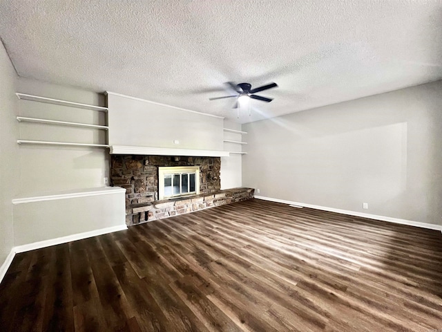 unfurnished living room with ceiling fan, a fireplace, wood-type flooring, and a textured ceiling