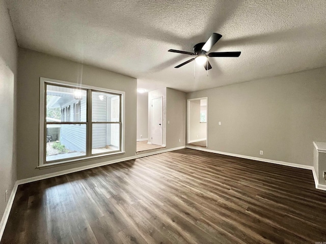 unfurnished room featuring dark wood-type flooring, ceiling fan, and a textured ceiling