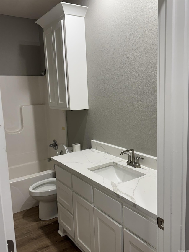 full bathroom featuring vanity, wood-type flooring, tub / shower combination, and toilet