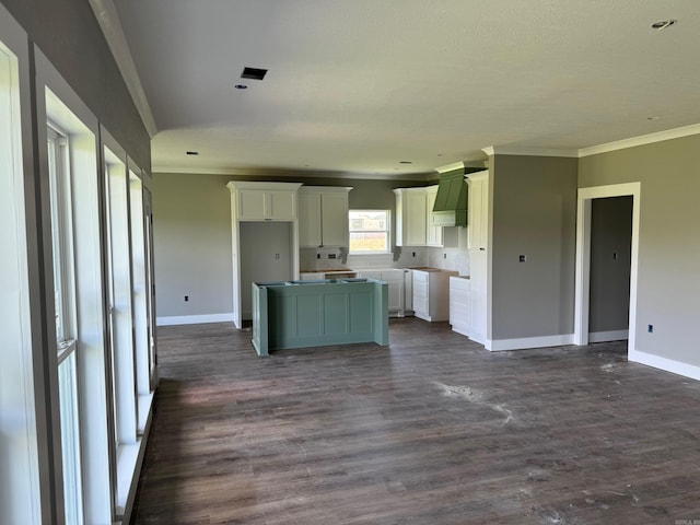 kitchen featuring white cabinets, crown molding, a kitchen island, dark hardwood / wood-style flooring, and custom range hood