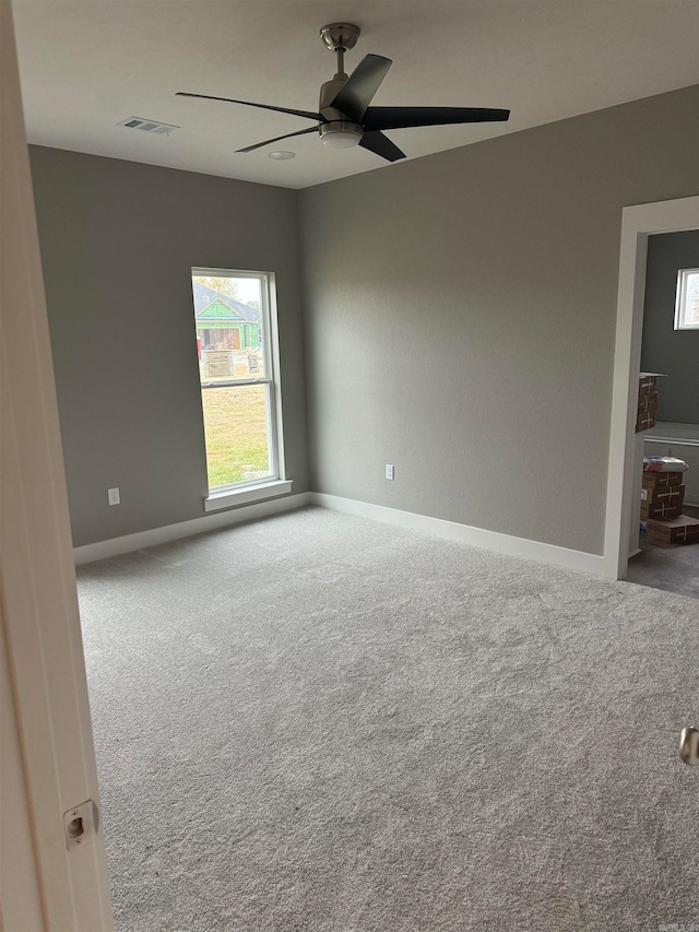 carpeted spare room with ceiling fan