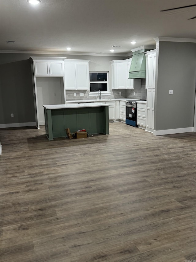 kitchen with premium range hood, white cabinets, dark hardwood / wood-style floors, a kitchen island, and stainless steel electric range