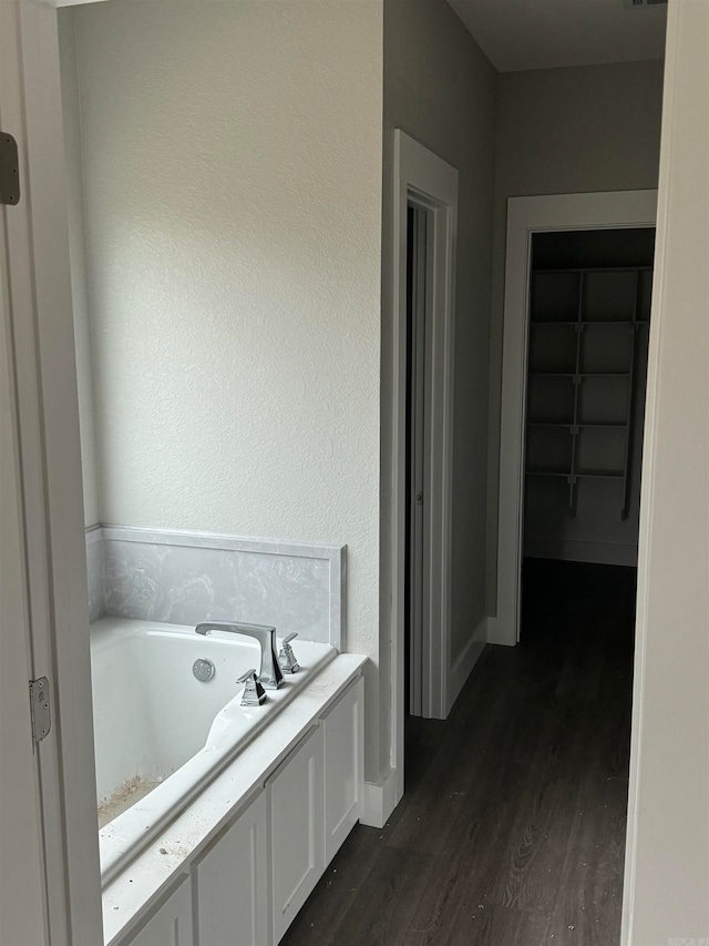 bathroom with a tub and wood-type flooring