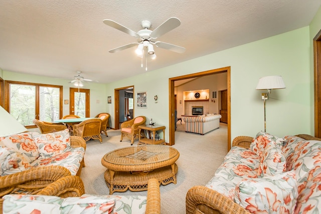 living room featuring light colored carpet, ceiling fan, and a textured ceiling