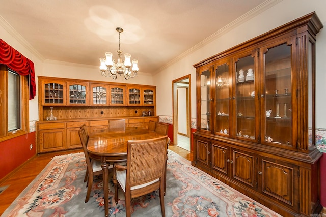 dining room featuring ornamental molding, an inviting chandelier, and dark hardwood / wood-style flooring