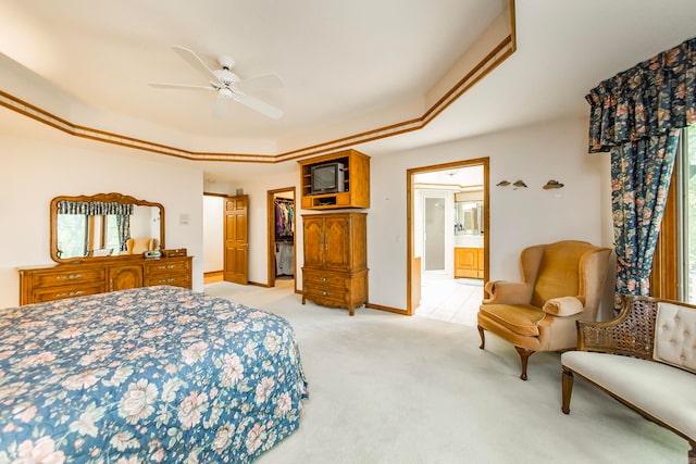 carpeted bedroom with ceiling fan, ensuite bathroom, and multiple windows