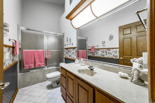 full bathroom featuring tile patterned floors, toilet, combined bath / shower with glass door, and vanity