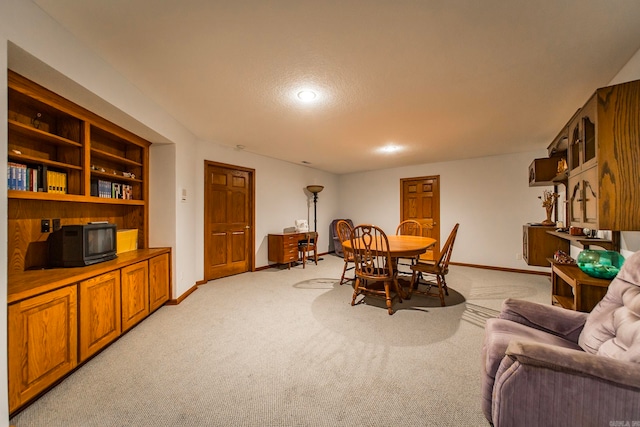 carpeted dining space with a textured ceiling