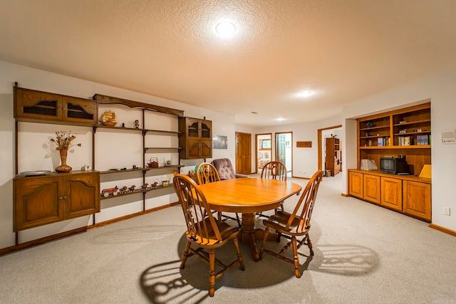 carpeted dining room featuring a textured ceiling