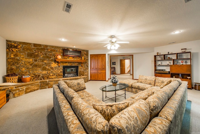 carpeted living room featuring a fireplace, a textured ceiling, and ceiling fan