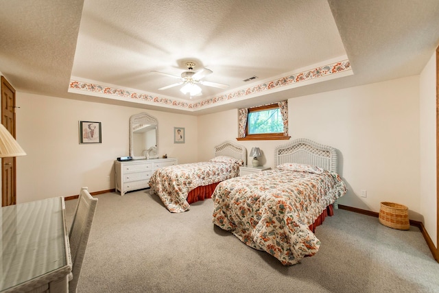 bedroom featuring carpet flooring, a tray ceiling, ceiling fan, and a textured ceiling