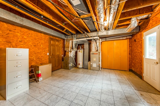 basement featuring gas water heater and heating unit