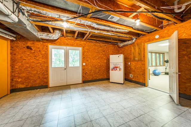 basement with french doors and white fridge