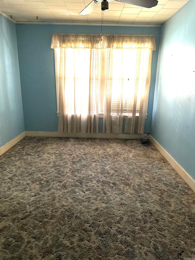 carpeted spare room featuring ceiling fan