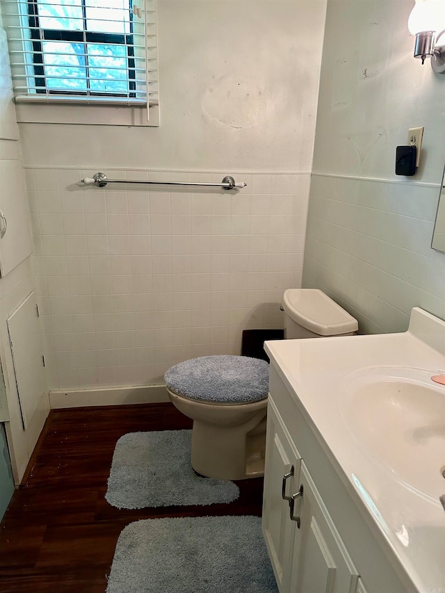 bathroom with tile walls, toilet, hardwood / wood-style floors, and vanity