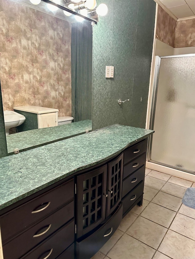 bathroom featuring vanity, toilet, an enclosed shower, and tile patterned floors