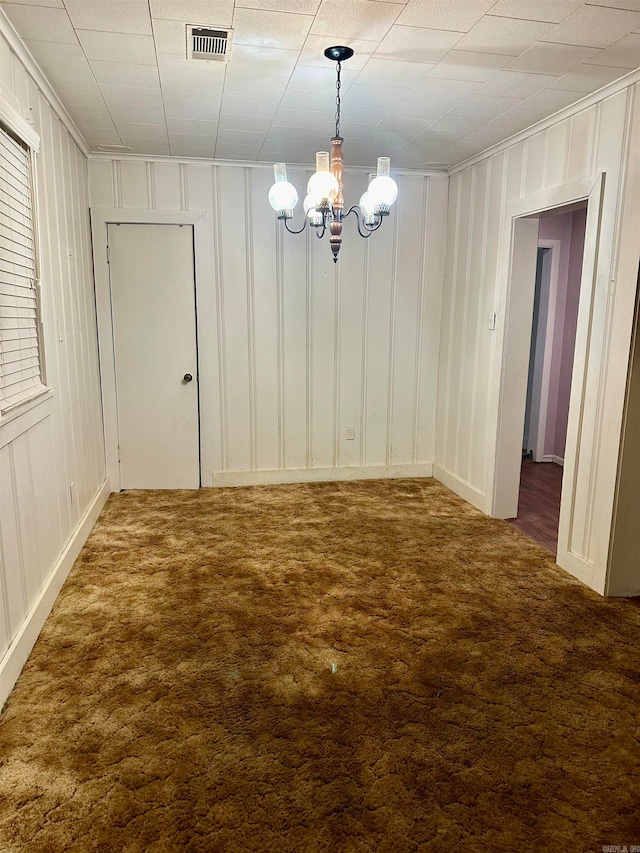 unfurnished dining area with an inviting chandelier and carpet