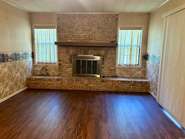 unfurnished living room with ornamental molding, dark hardwood / wood-style flooring, and a fireplace