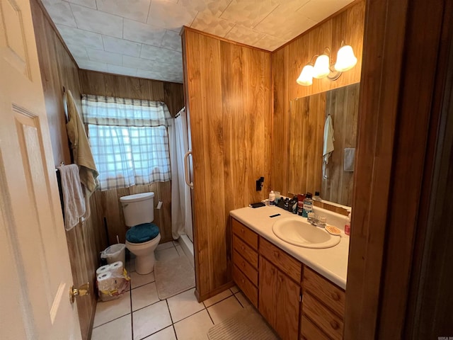 bathroom featuring a shower with shower curtain, tile patterned flooring, wooden walls, toilet, and vanity