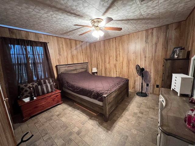 unfurnished bedroom featuring ceiling fan and wooden walls