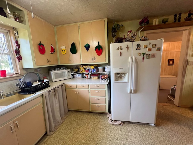 kitchen with cream cabinetry and white appliances