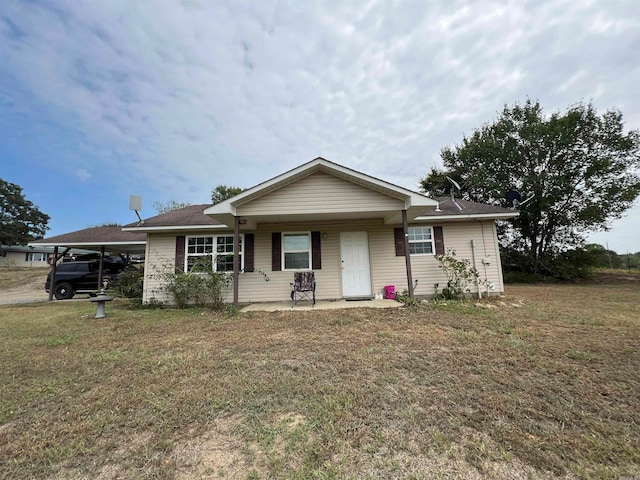 single story home featuring a front lawn and a carport