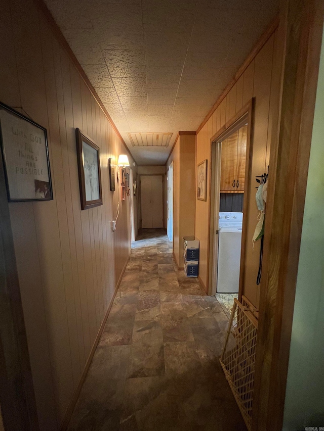 hallway featuring wooden walls and washer / clothes dryer