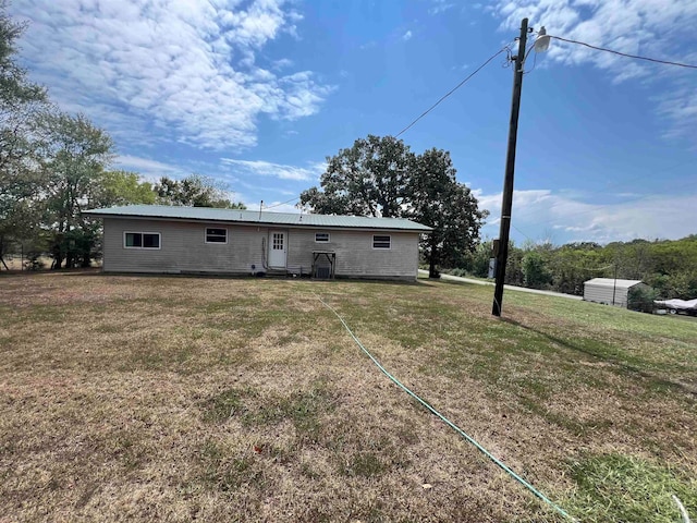 rear view of property featuring a lawn