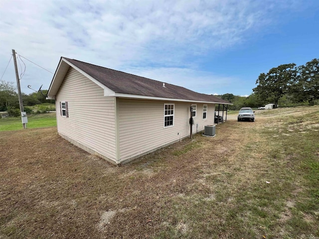 view of home's exterior with cooling unit and a yard