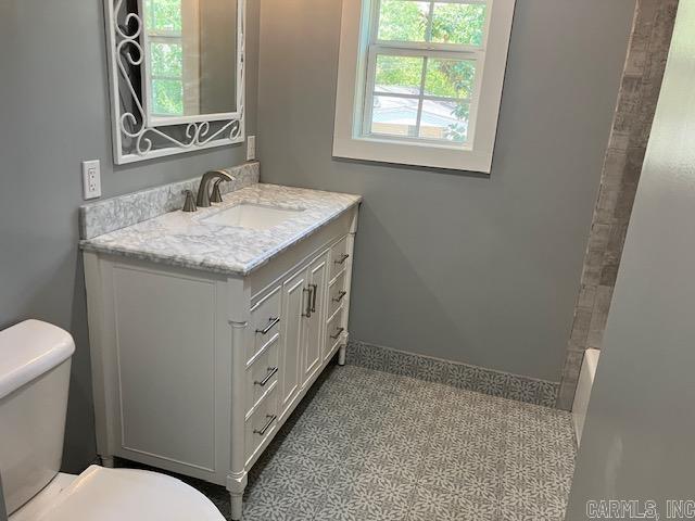 bathroom featuring walk in shower, a bathing tub, vanity, and toilet