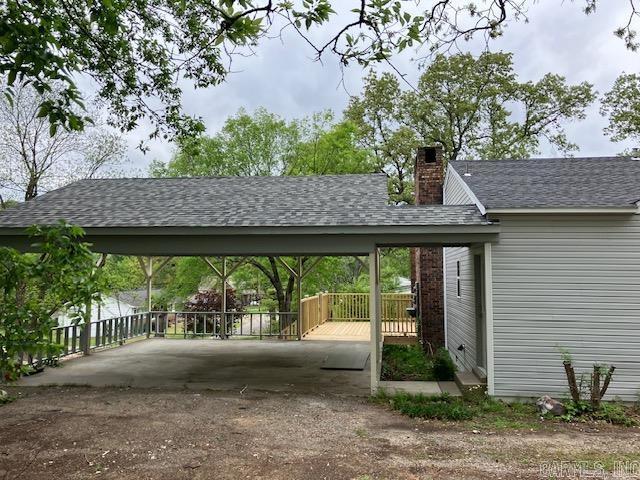 view of vehicle parking with driveway and a carport