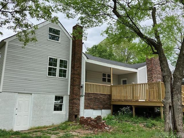 rear view of property with a chimney and a deck