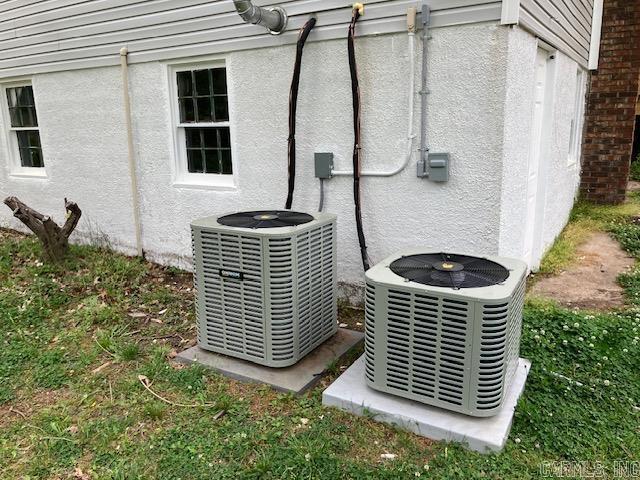 exterior details with stucco siding and central AC unit