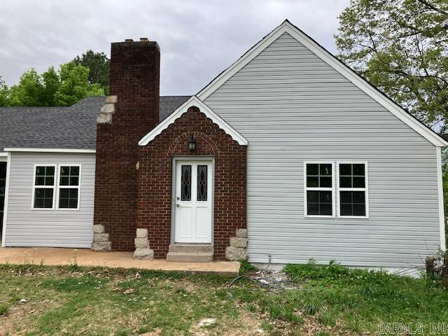 back of house with entry steps and a chimney