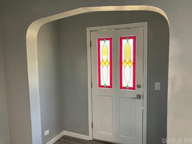 foyer entrance featuring dark wood-style floors and baseboards