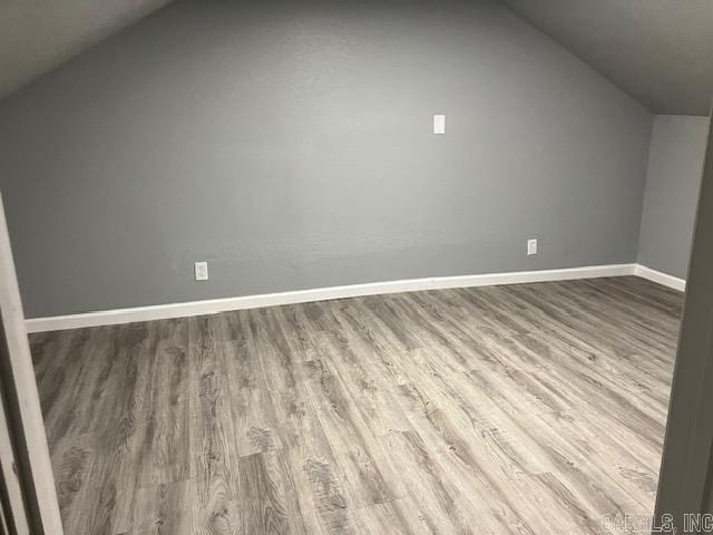 bonus room with vaulted ceiling, wood finished floors, and baseboards