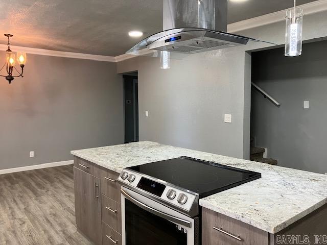 kitchen with light wood finished floors, electric range, baseboards, crown molding, and exhaust hood