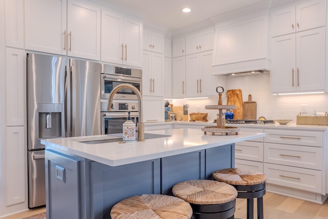 kitchen with a center island, a breakfast bar area, appliances with stainless steel finishes, custom exhaust hood, and white cabinets