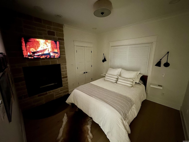 bedroom featuring baseboards, ornamental molding, and a fireplace