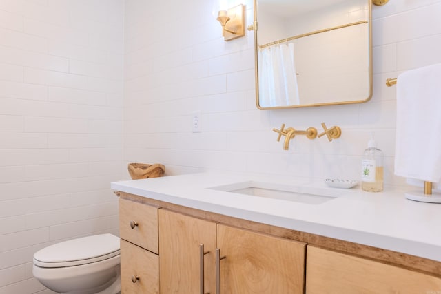 bathroom featuring tile walls, a shower with curtain, toilet, and vanity