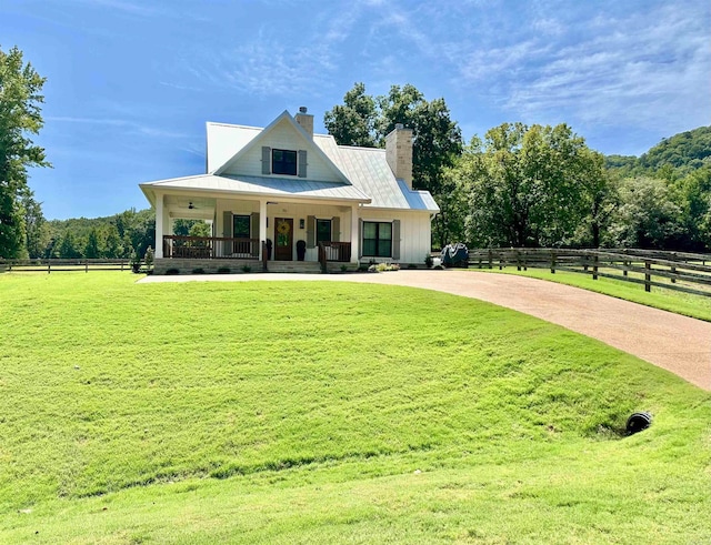 view of front facade featuring a porch, a rural view, and a front lawn