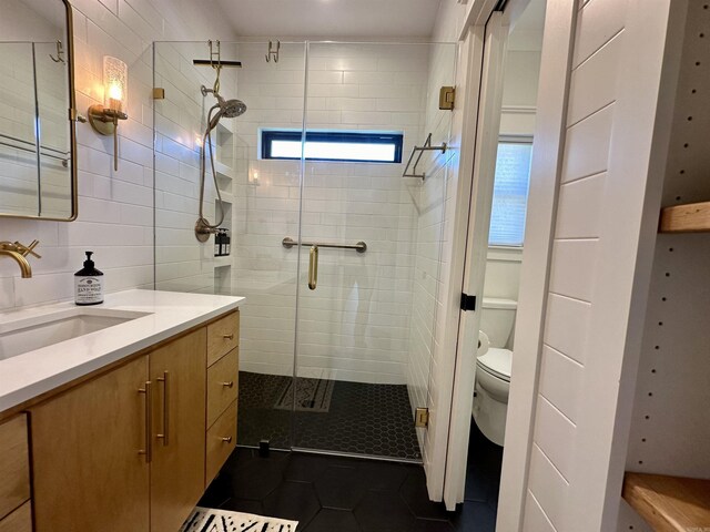 full bathroom with tile patterned floors, toilet, a stall shower, tile walls, and vanity